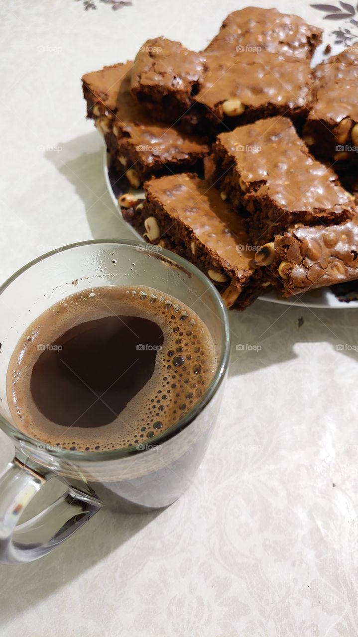 homemade baked brownie cake with nuts and hot coffee