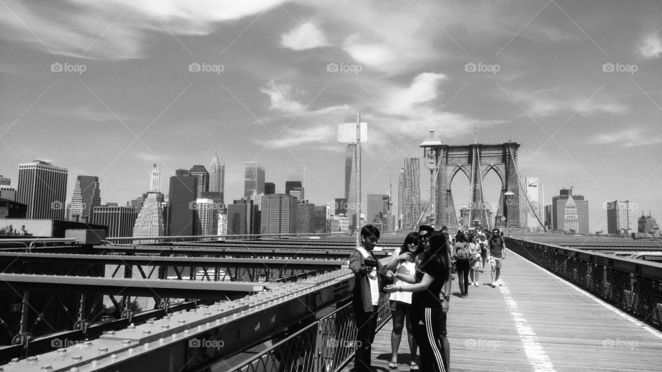 Monochromatic shot of a summer day walk on the Brooklyn Bridge.