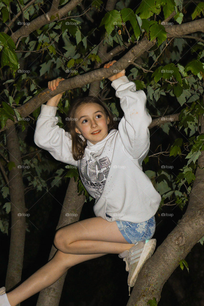 girl playing in a tree at night