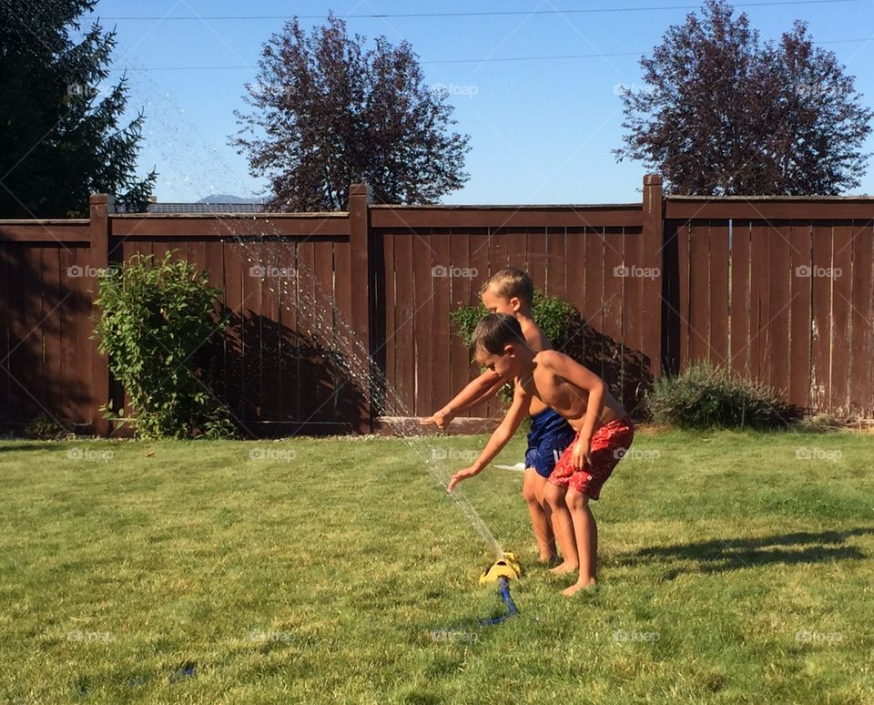 Kids playing in the sprinkler 