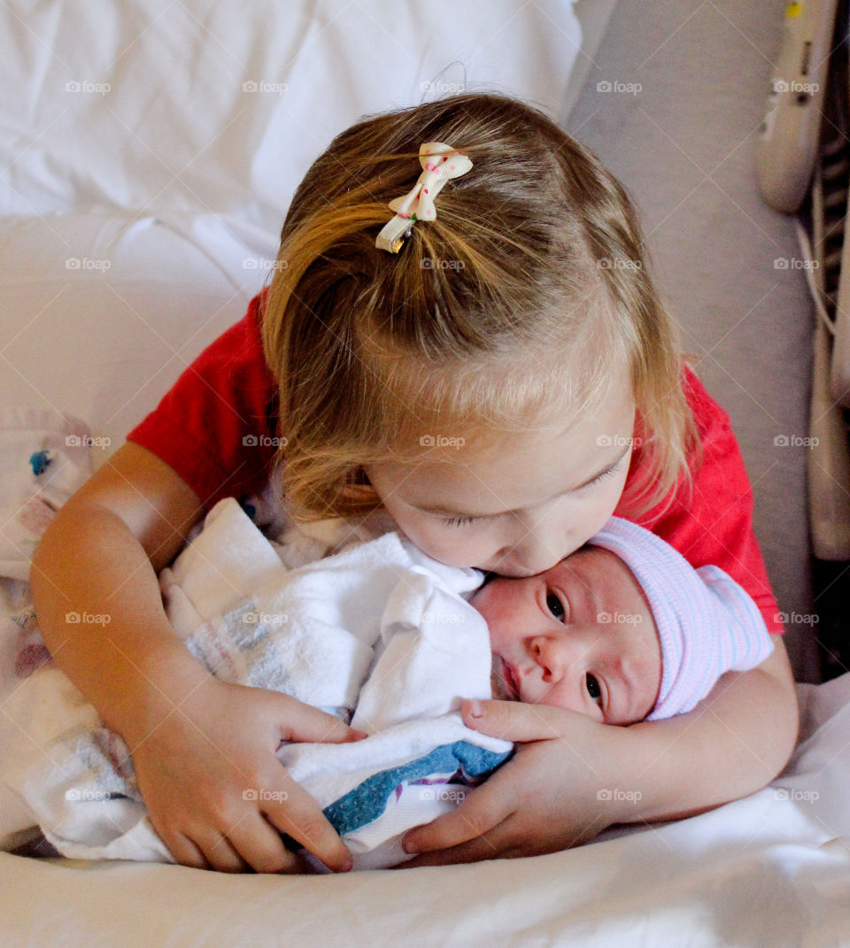 Portrait of girl kissing baby