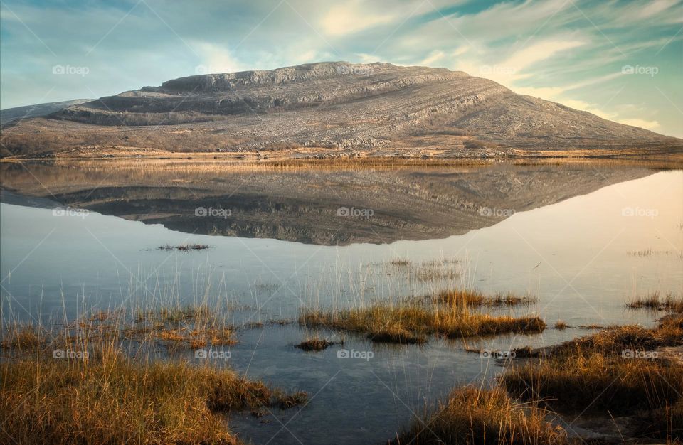 Beautiful morning landscape scenery with mountains reflected in Lake at Burren National Park in county Clare, Ireland