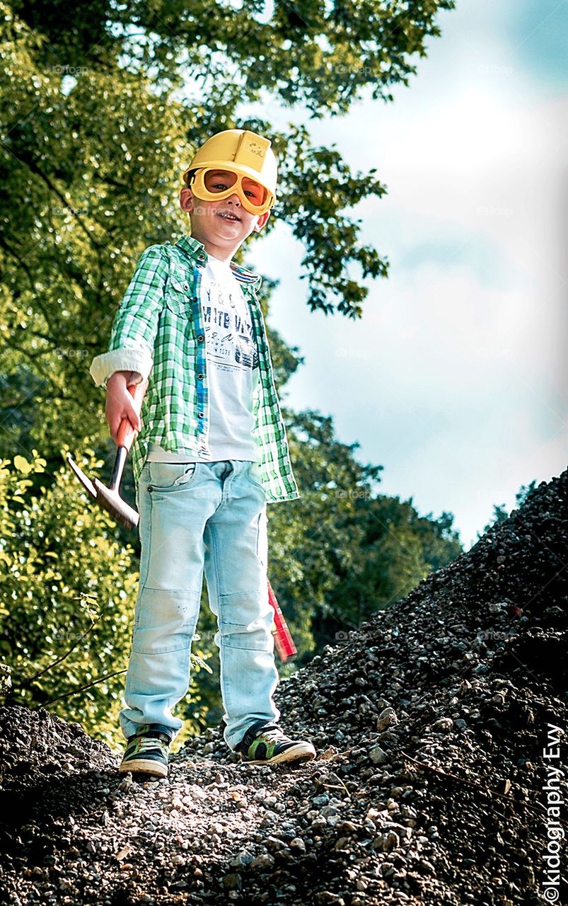 Little Young boy contruction worker on mountain with tools