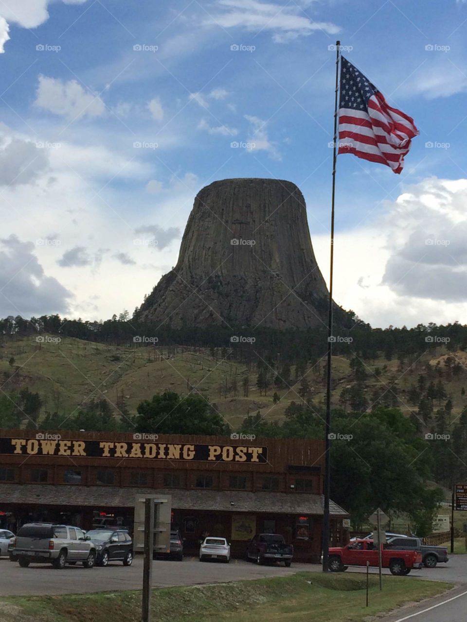 Devil’s tower with flag and trading post in the background 