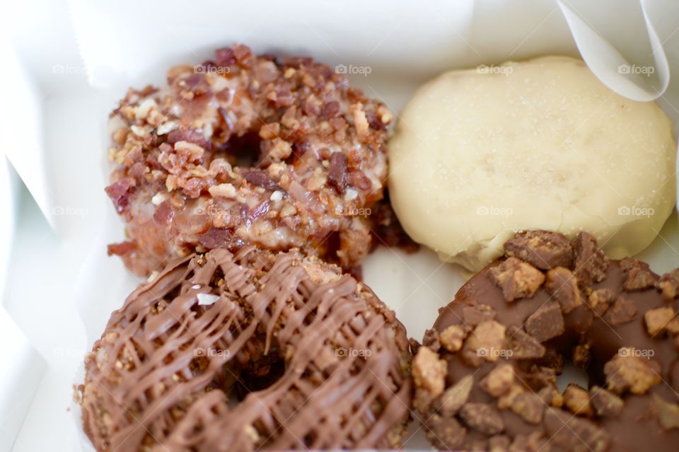 maple,bacon,Reese’s cup and cream cheese freshly made doughnuts in a box