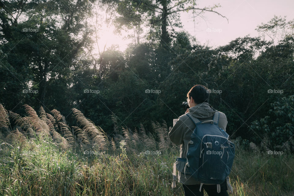 Backpacker taking a photo in the forest 