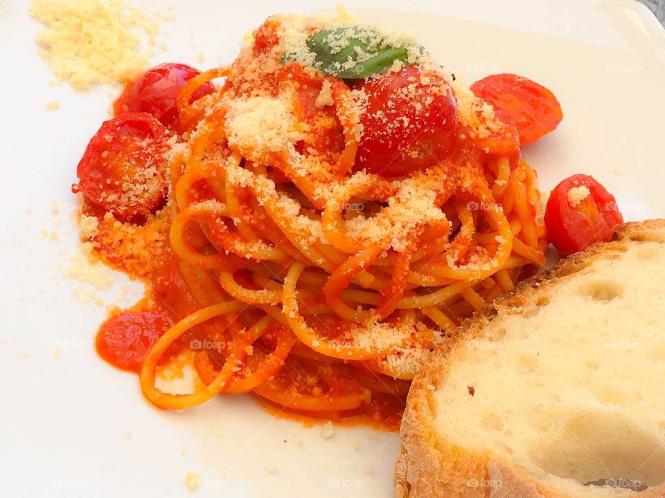 Italian food, dinner. Classic mediterranean dish with pasta, spaghetti, bread and tomatoes.