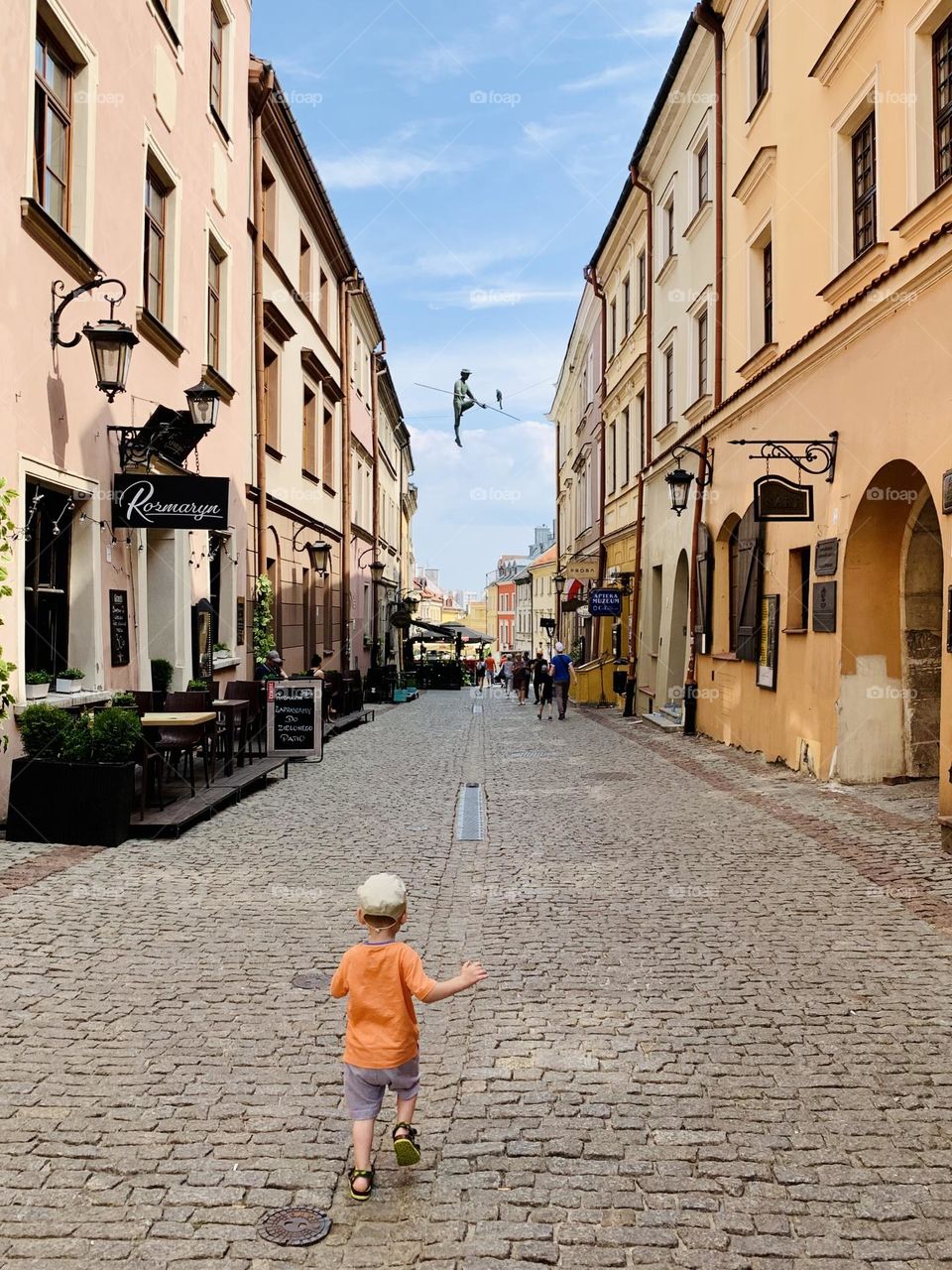 Little boy runs, old town street in Lublin, Poland