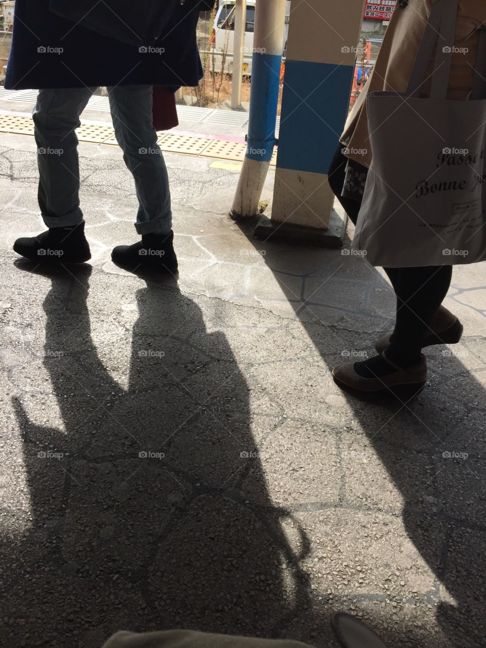 Shadows of people passing by in a train station platform in Tokyo Japan

