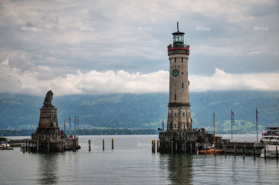 Lighthouse and lion statue against aky at bodensee