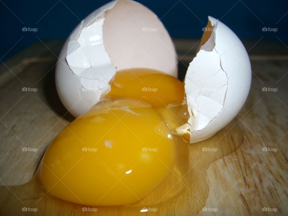 Broken Double Yolk White Egg on Wooden Cutting Board