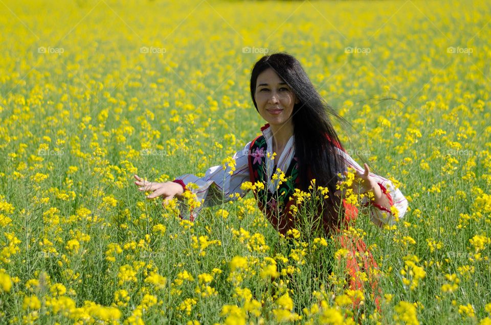 Portrait of My Beautiful Wife in Rapeseed Field. She is dressed in Traditional Bulgarian Folk Costume