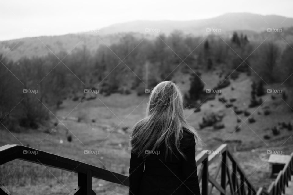 young woman with long hair photographed from behind on a mountain