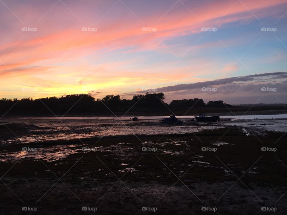 Red sky and clouds and boats