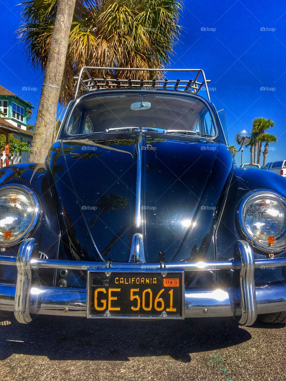 Classic 1966 VW bug with Black antique California license plate in tropical setting. 