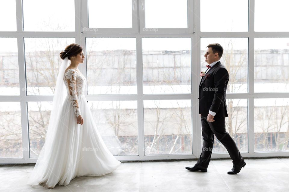 Photo session of newlyweds against the background of panoramic windows