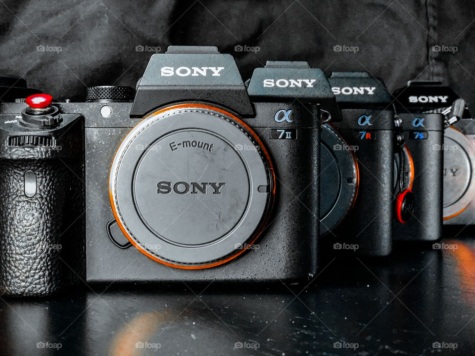 Sony alpha line of cameras in a staggered row showing model badge. Sony a7ii, a7s, a7sii,a7r 