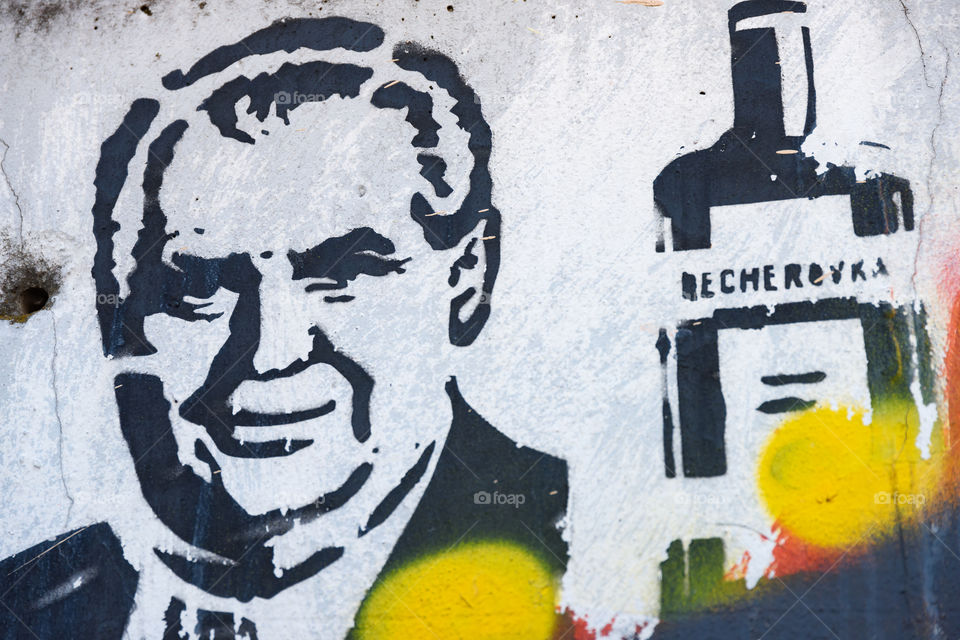 Prague, Czech Republic - July 3, 2017: Political graffiti painting on the wall at the outskirts of Prague portraying Czech President Miloš Zeman and Becherovka liquer bottle. 