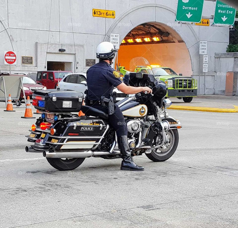 Police officer on duty stopped at traffic light on motorcycle
