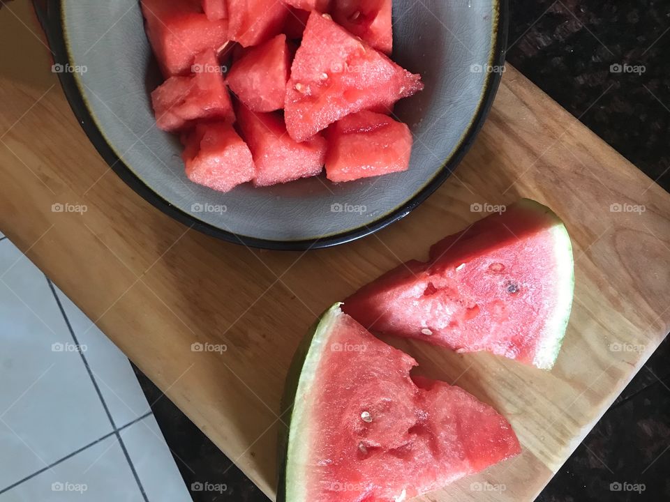 Red, juicy and delicious cut up Watermelon in a bowl and cutting board in the kitchen. Eating healthy for my news years resolutions. USA, America
