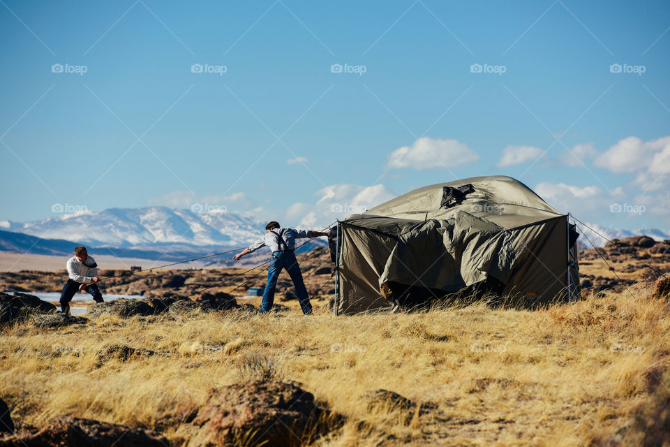 Pitching a tent in the strong wind 