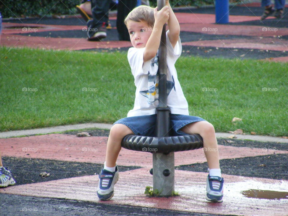 A boy on playground equipment.