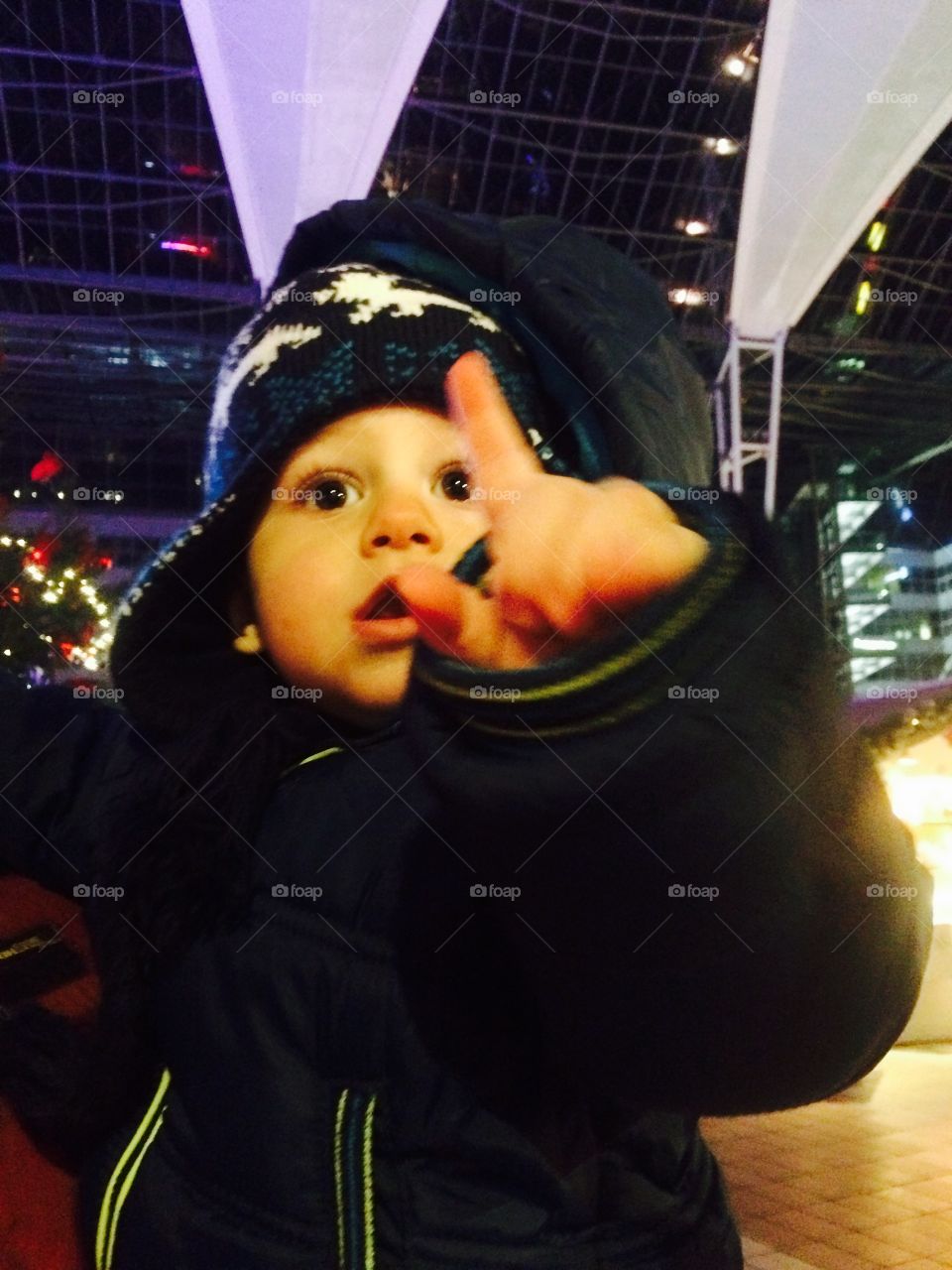 Close-up of a little boy pointing with hand in city