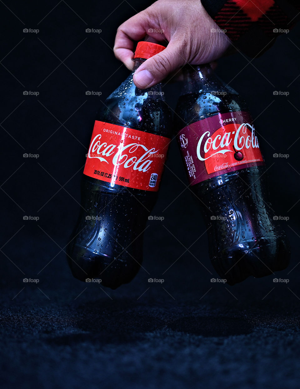 Close up shot of two Coca Cola with black background with the mists at the studio.  