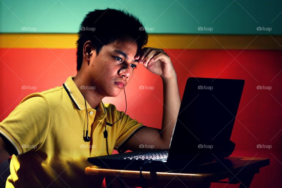 young asian teen working on a laptop computer