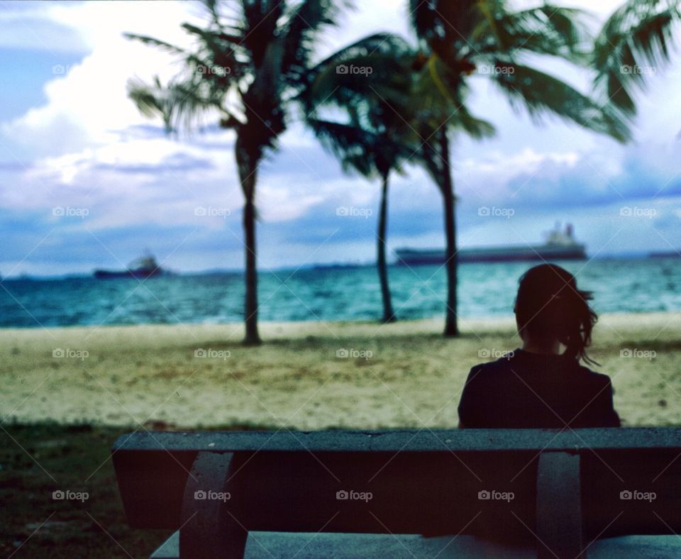 Silhouette of a girl sitting in front of beach