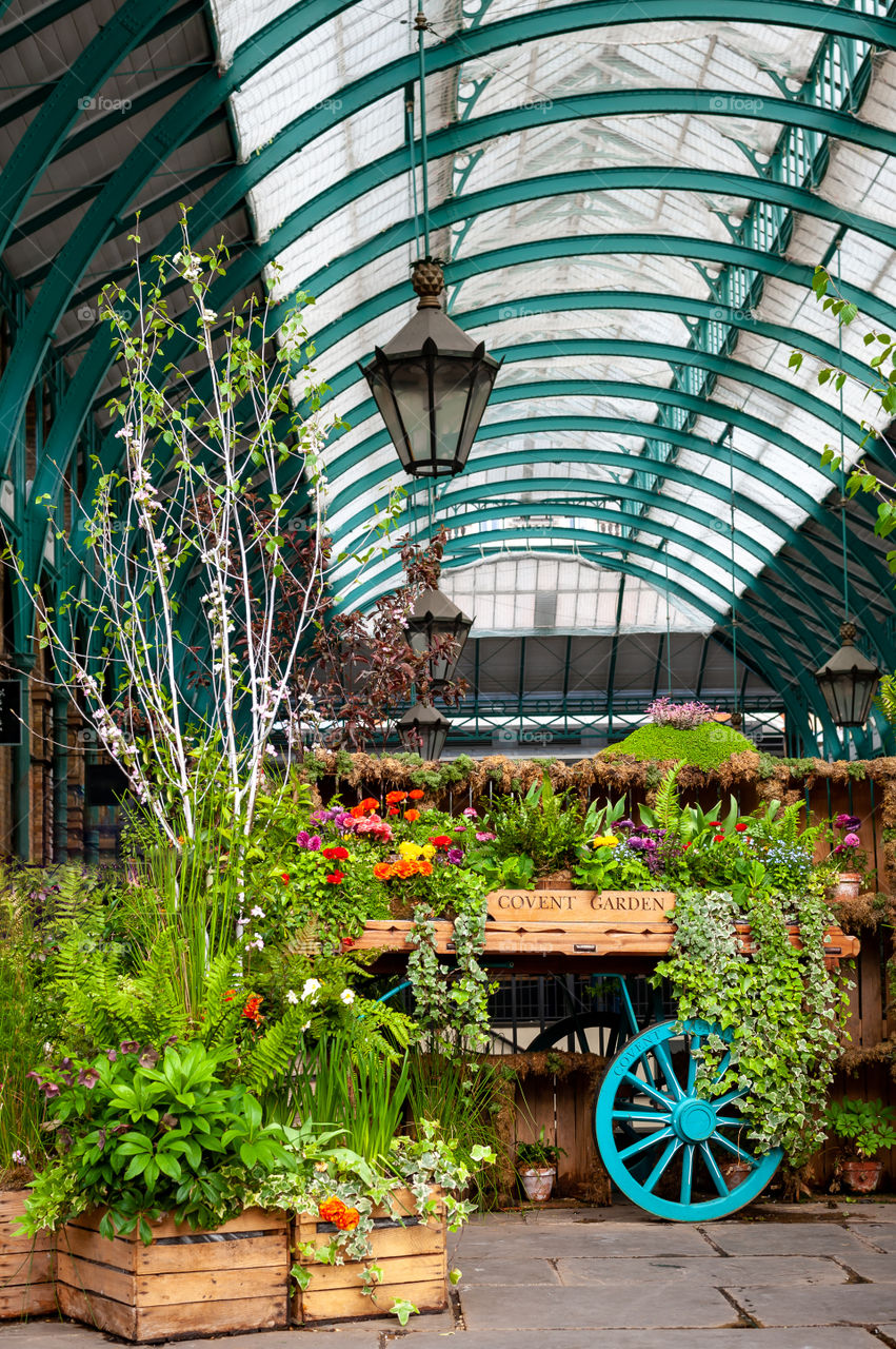 Cart full of flowers and plants on display in old flower and vegetable market place. Covent Garden Market. London. UK. Europe.