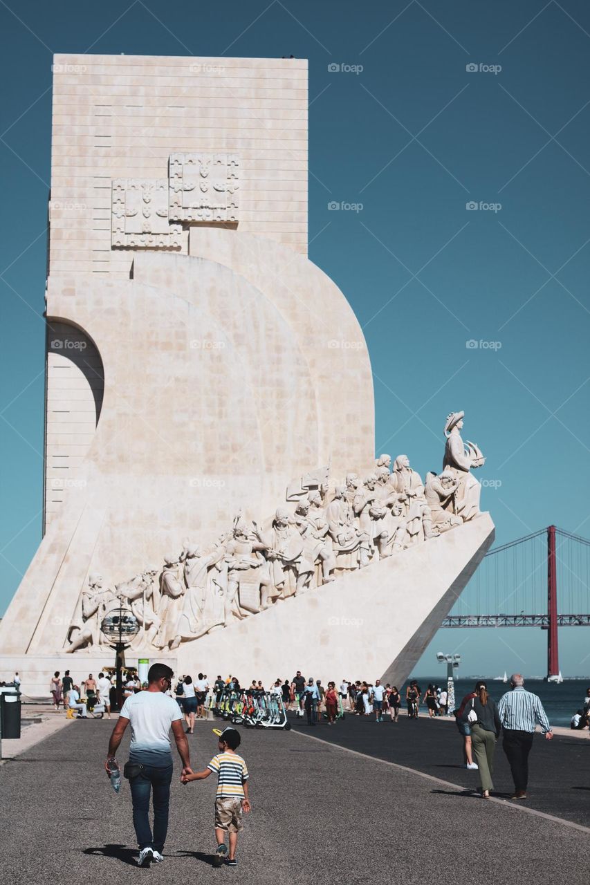 A father holding hands with his son in public.