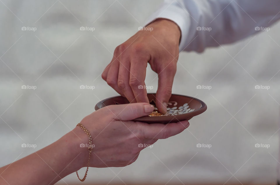 A person taking gold ring from plate