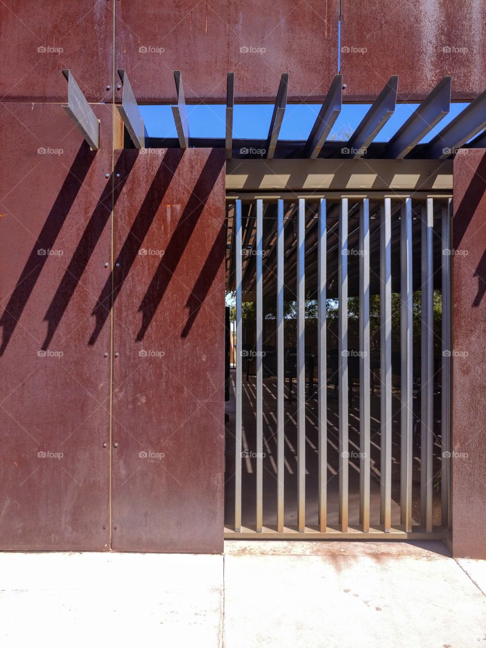 Slated steel door with iron rust wall. Scottsdale Arizona