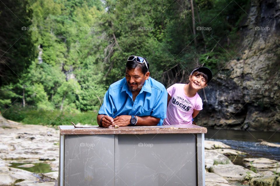 Father and daughter at the desk in the wilderness