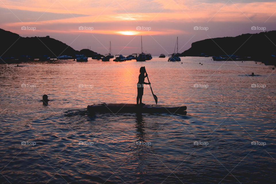 Child doing padelsurf at sunset.