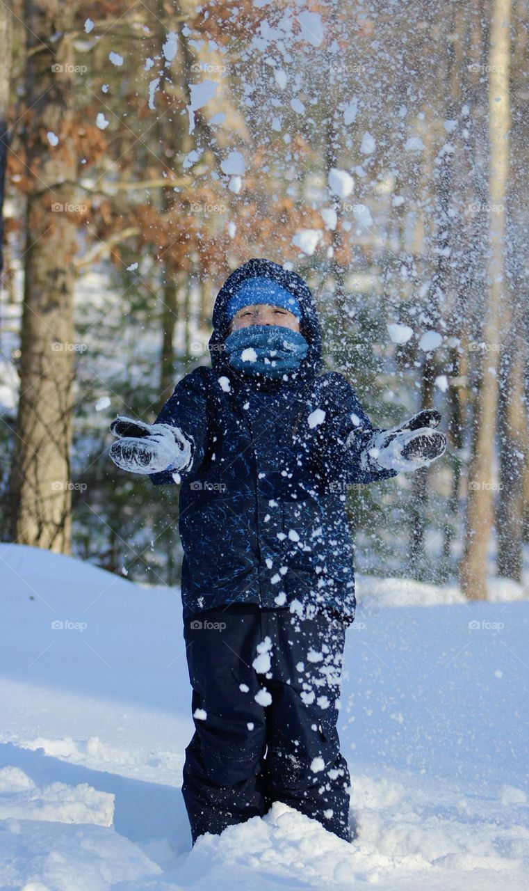 Snow Day Blast; Young Boy throwing snow in the air