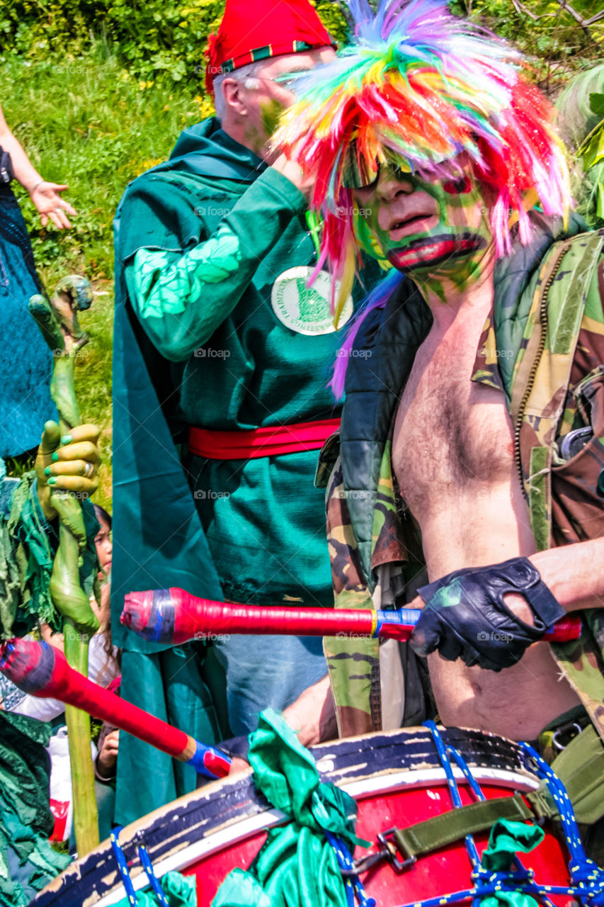 A man in a colourful wig, plays drums at Hastings Traditional Jack in the Green, U.K. 2008