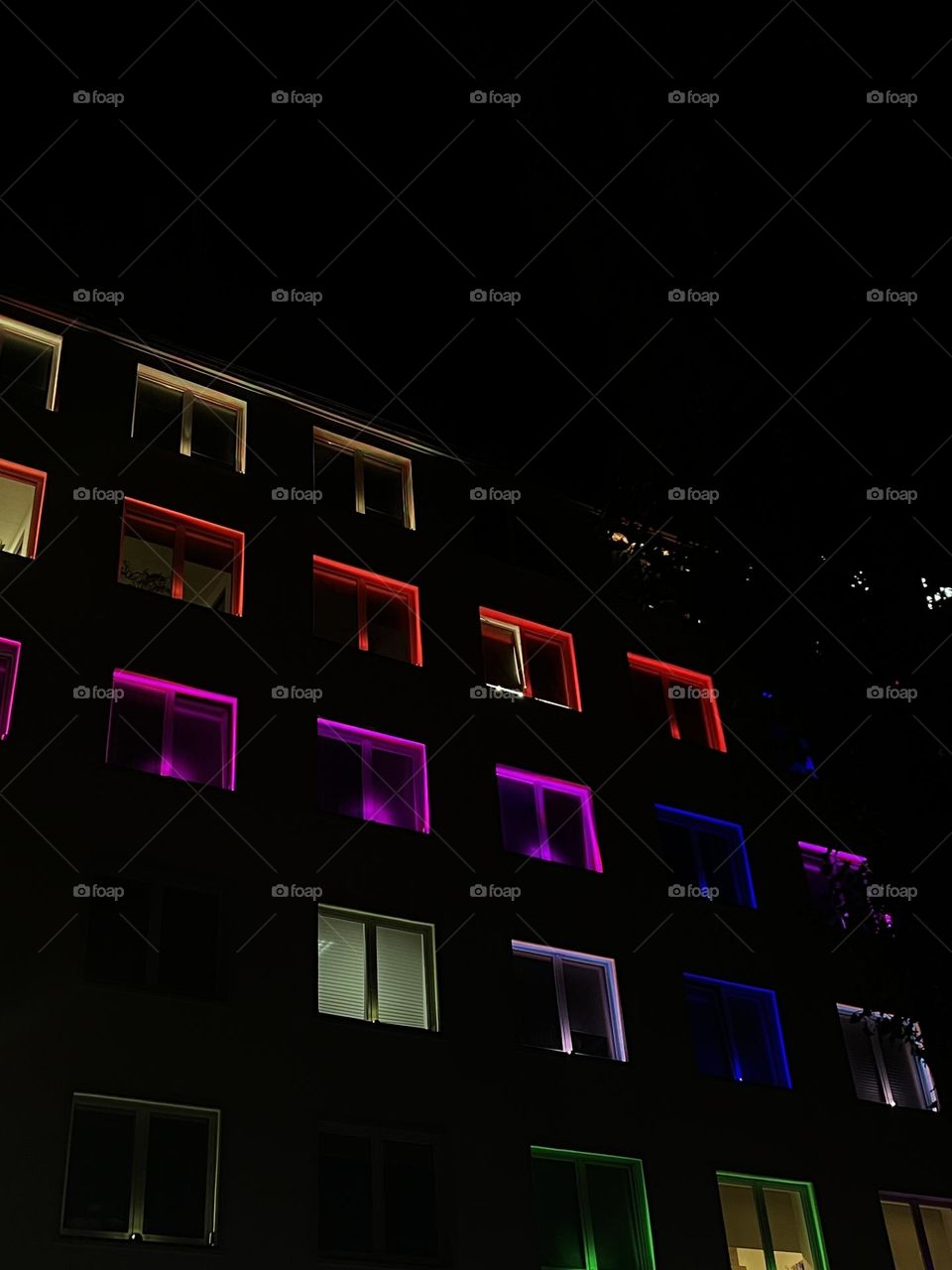 Bright, colorful illustrations on the windows of a multi-storey building