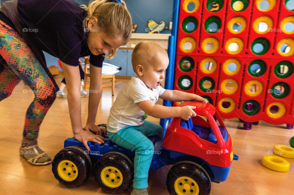 girl is playing with her younger brother