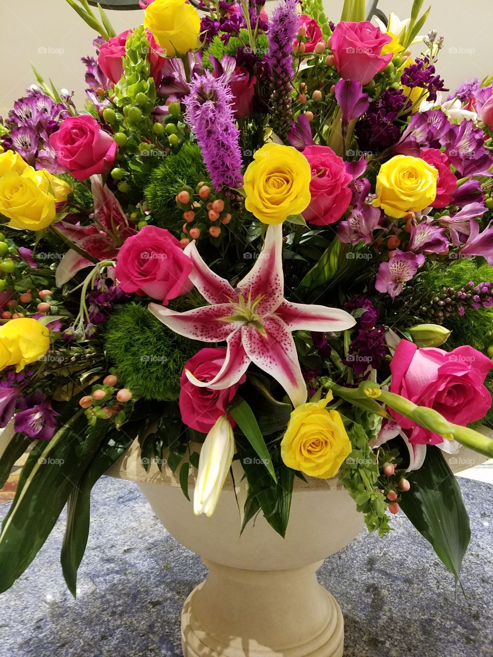 flower arrangement variety of roses lilies and others vibrant colors centerpiece for large round marble table