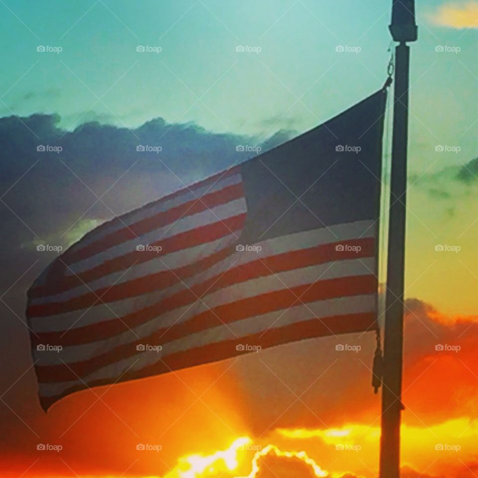 American flag with a sunset in the background