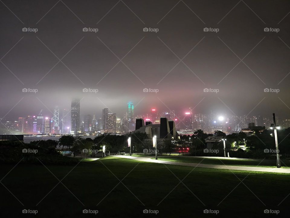 Looking at Hong Kong Victoria Harbour night view from West Kowloon Cultural District on a rainy night