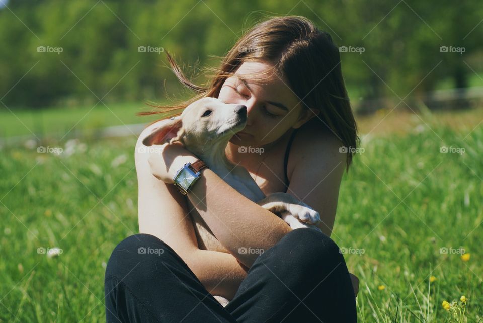 Girl with dog. A girl is hugging a whippet puppy