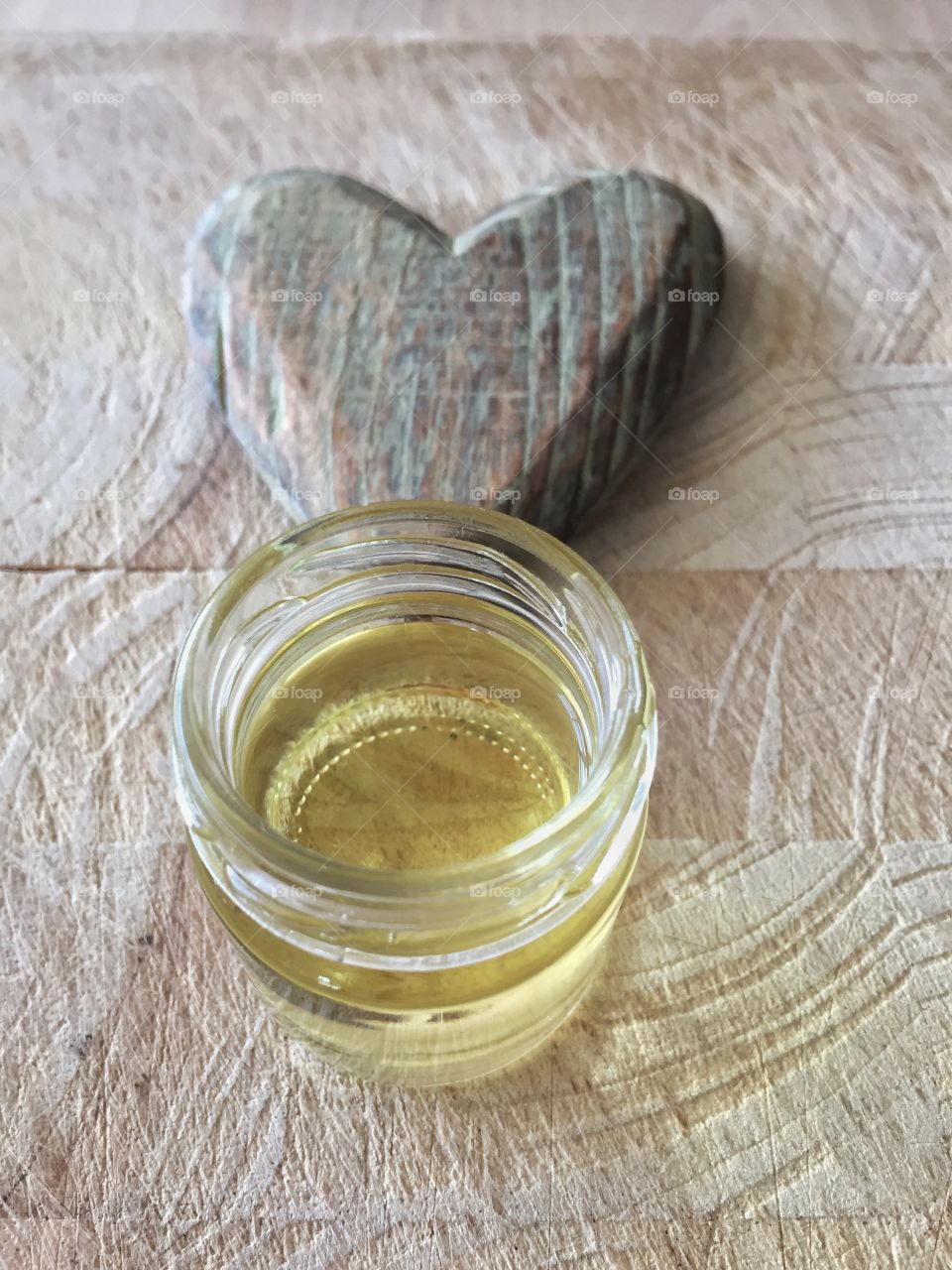 Almond oil with heart on wooden plate