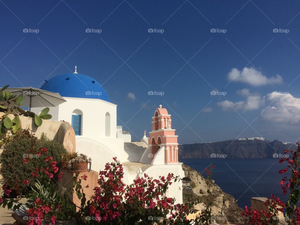 Santorini church . Beautiful church and tropical flowers on  Santorini island, Mediterranean sea, Greece 