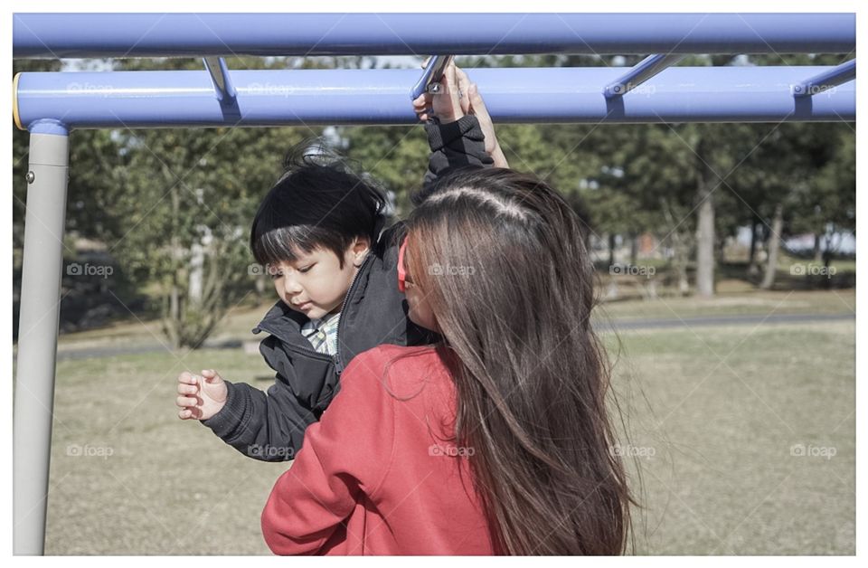 Mother helping child in playground 