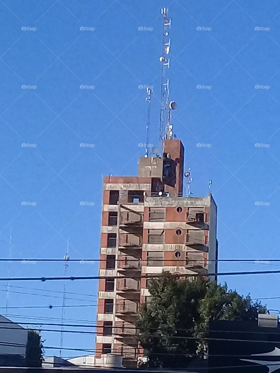 torre de departamentos con importante antena de radio en la altura. General Rodríguez, provincia de Buenos Aires.  Argentina