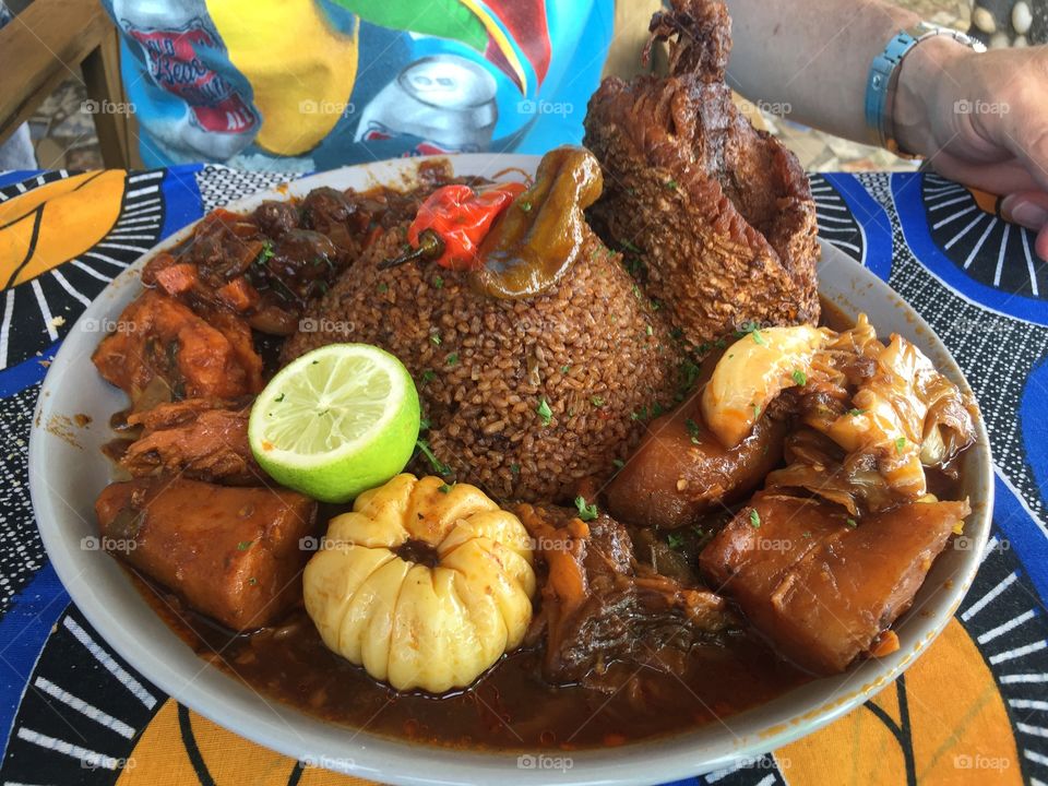A huge plate of Céebujën or Thieboudienne, a traditional Senegalese dish of rice, fish, and vegetables.