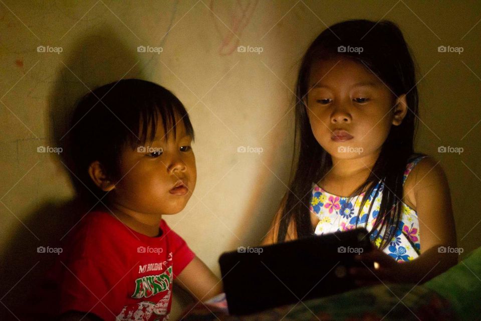 Two kids watching video from smartphone